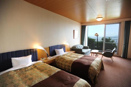 a hotel room with two beds and a window at 国家公務員共済組合連合会びわこ保養所（KKRホテルびわこ） in Otsu