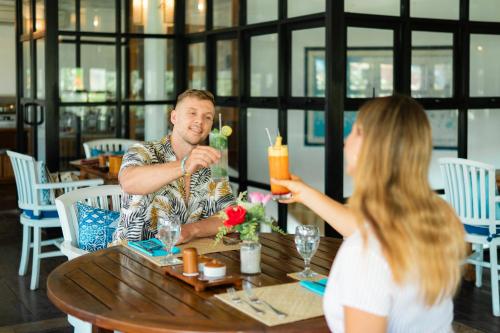 un homme et une femme assis à une table dans un restaurant dans l'établissement Villa Almarik Resort, à Gili Trawangan