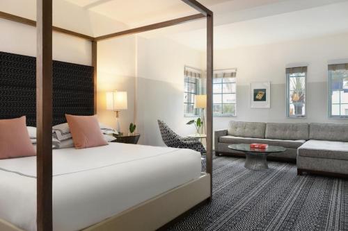 a hotel room with a bed and a couch at Kimpton Surfcomber Hotel by IHG in Miami Beach