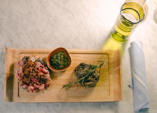 a cutting board with a bowl of food on a table at Kimpton Surfcomber Hotel by IHG in Miami Beach