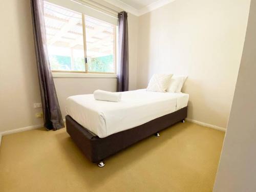 a bedroom with a bed in a room with a window at Glen’s Haven with Lakeviews in Wagga Wagga