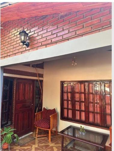 uma casa com uma cadeira, uma mesa e uma porta em Parana house em Puerto Iguazú
