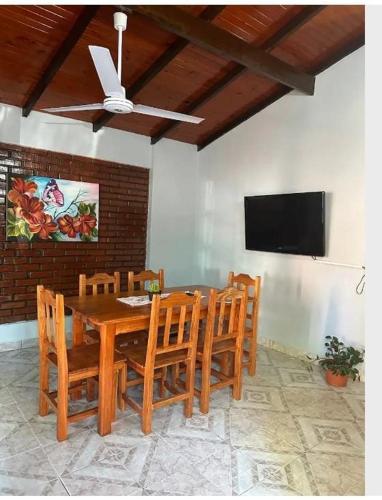 a dining room table with chairs and a flat screen tv at Parana house in Puerto Iguazú