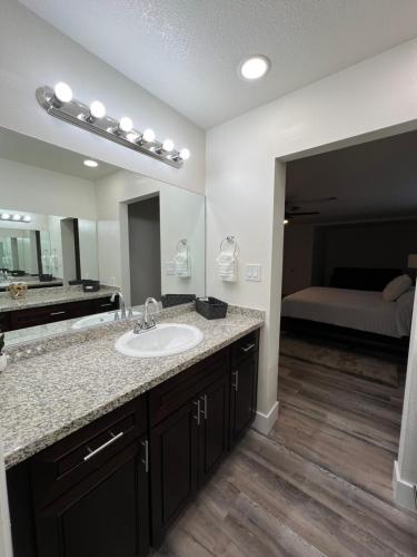 a bathroom with a sink and a large mirror at Pampas House in Las Vegas