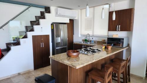 a kitchen with a counter top and a staircase at Lovely 4 bedroom penthouse Terra PH23 QueridaEstancia in Nuevo Vallarta