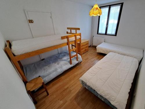 une chambre avec deux lits superposés et un lit dans l'établissement Appartement spacieux avec belle terrasse, proche pistes et commerces de Pra Loup 1600 - FR-1-165A-188, à Uvernet