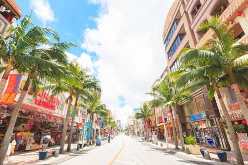 a city street with palm trees and buildings at アメニティーハウス宮城501 in Tomari