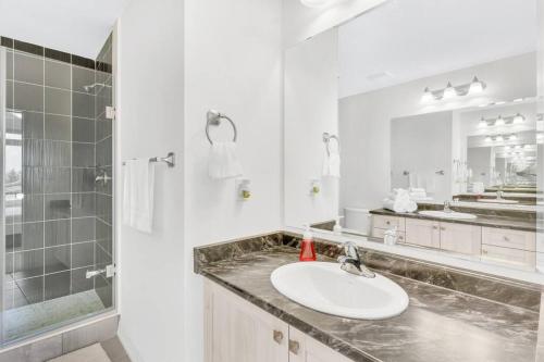 y baño blanco con lavabo y ducha. en Tulip Smartments Brampton-Spacious 4 Bedroom Near Airport, en Brampton