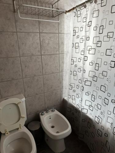 a bathroom with a toilet and a shower curtain at Sol y Vida in Godoy Cruz