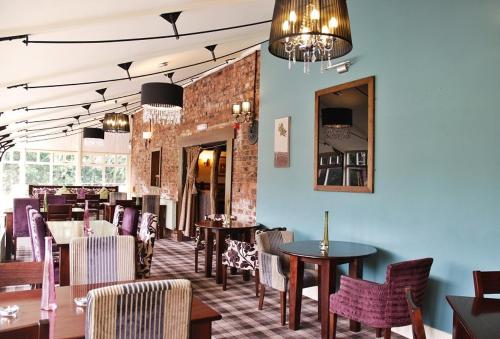 a restaurant with tables and chairs and a brick wall at The Gardeners Country Inn in Hull