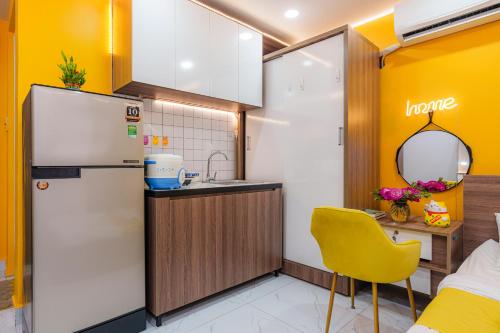 a kitchen with a refrigerator and a yellow chair at Luxury Condotel Sai Gon 3 in Ho Chi Minh City