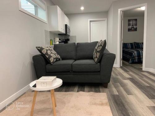 a living room with a couch and a table at Guest Suite in Regina - Queen Bed in Regina