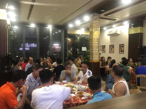 a group of people sitting at tables eating food at Đức Lộc 2 Hotel in Hue