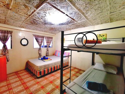 a room with two bunk beds and a window at Stay N Save B&B in Oslob