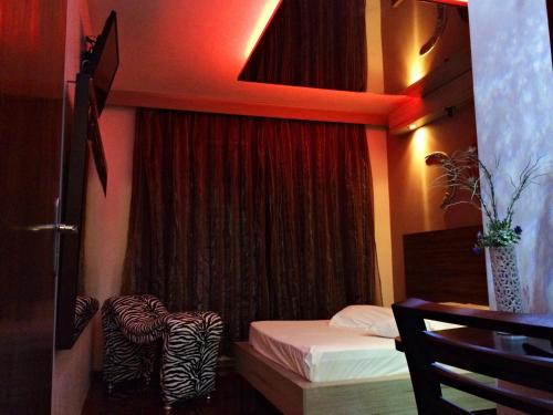 a room with a bed and a window with a curtain at Rainbow Motel (Adult Only) in Itupeva
