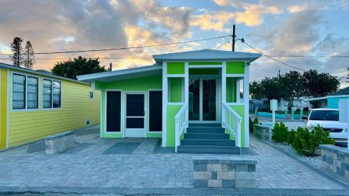 a small yellow and green house with a porch at Key Lime Tiny Home New&Cozy in Sarasota