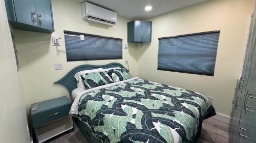 a bedroom with a bed with a camouflage blanket and a window at Key Lime Tiny Home New&Cozy in Sarasota