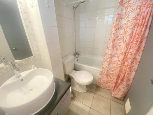een badkamer met een wastafel, een toilet en een douchegordijn bij Departamento verano la serena in La Serena