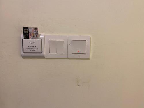 a lightswitch on a white wall with a socket at B & B 31 Kota Kinabalu in Kota Kinabalu
