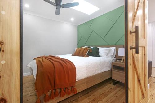 1 dormitorio con 1 cama y ventilador de techo en Stylish Guesthouse in the Heart of Belrose, en Belrose