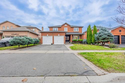 a large brick house with a driveway at Cozy Haven Retreat 2Bed Basement in Whitby