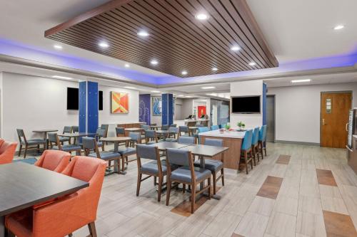 a restaurant with tables and chairs and a flat screen tv at Holiday Inn Express Hershey-Harrisburg Area, an IHG Hotel in Hershey