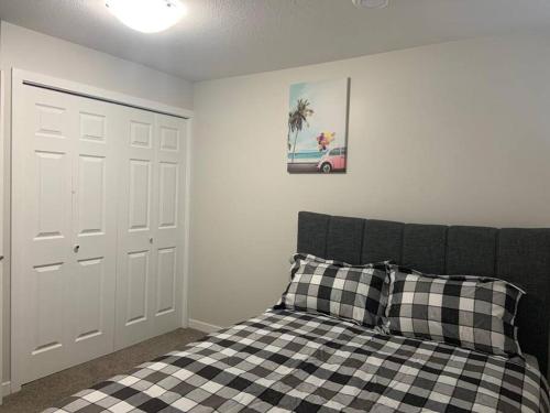 Un dormitorio con una cama con una almohada a cuadros. en Guest Suite with Queen Bed -Home Away from Home, en Regina