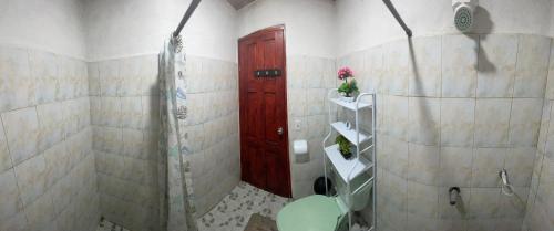 a bathroom with a shower and a red door at Cabaña la India in Valle de Anton