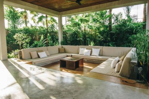 a living room with a couch and a table at ZIN Berawa Villas & Bungalows in Canggu