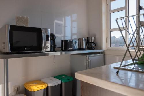 uma cozinha com um balcão com uma televisão numa prateleira em North Star Flats @ Dom Luís I Bridge em Vila Nova de Gaia