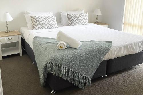 a bed with a blanket and a towel on it at Suburban Bliss - Elegant Villa 1 in Wagga Wagga