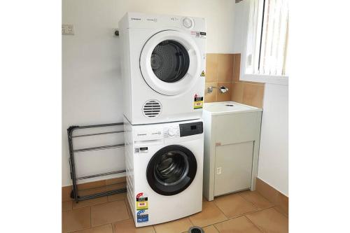 a washer and dryer in a small room at Suburban Bliss - Elegant Villa 1 in Wagga Wagga