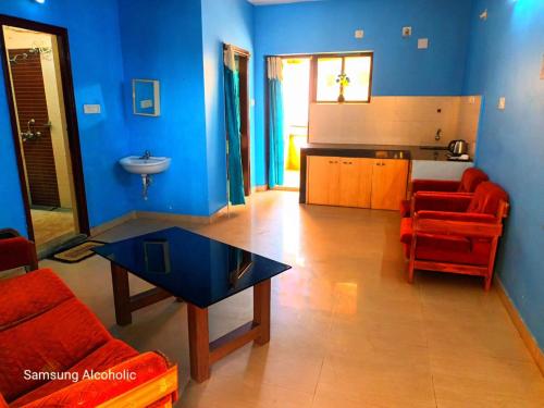ein blaues Wohnzimmer mit einem Sofa und einem Tisch in der Unterkunft Hotel Ashiana Lagoon in Puri