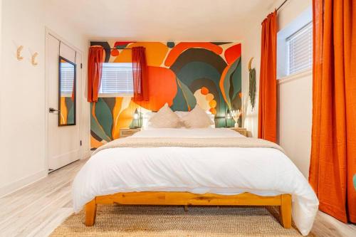a bedroom with a large bed with a colorful wall at Riverside Luxe: Stylish Designer Retreat in Reno