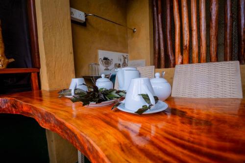 ein Holztisch mit weißen Vasen darüber in der Unterkunft Rainforest View in Deniyaya