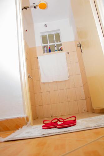 two red slippers on the floor in a bathroom at Decii homes in Ruaka