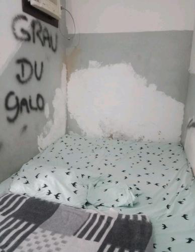 łóżko w pokoju z rozbitą ścianą w obiekcie Quarto privativo w mieście Rio de Janeiro