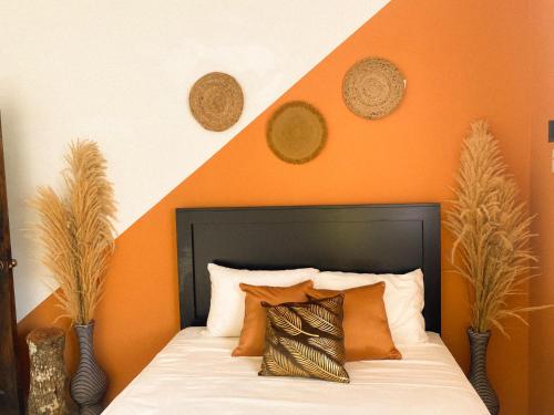 House of Zen في Santa Cruz: غرفة نوم برتقالية وبيضاء مع سرير مع وسائد