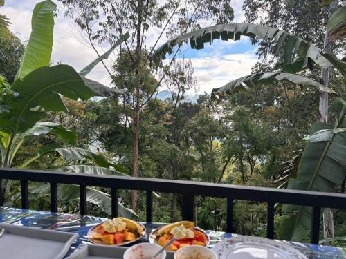 una mesa con platos de fruta en el balcón en The Bliss Homestay, en Ella