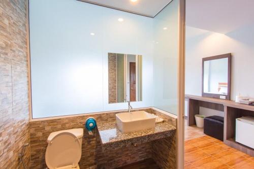 bagno con lavandino, servizi igienici e specchio di PhetPhangan Hotel a Ban Tha Kup