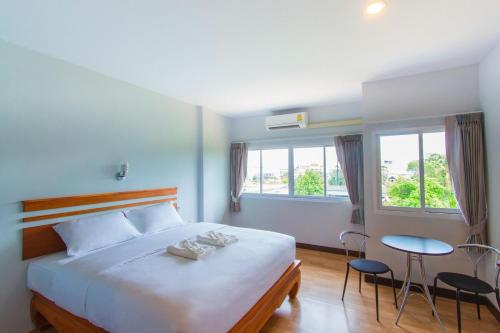 Ban Tha Kup的住宿－PhetPhangan Hotel，卧室配有一张床和一张桌子及椅子