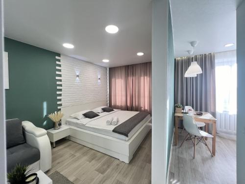 um quarto com uma cama, uma secretária e uma cadeira em Апартаменты с видом на город em Pavlodar