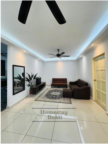 a living room with a couch and a ceiling fan at Homestay Bukit Roses in Beranang