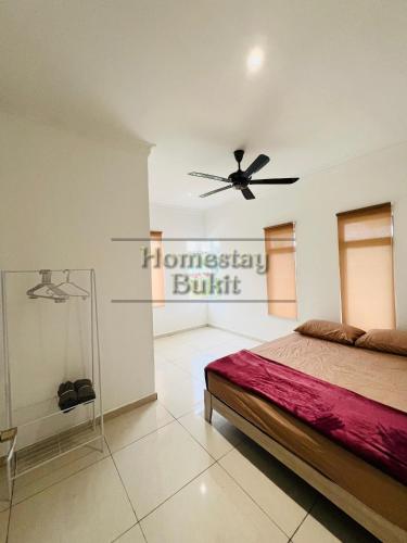 um quarto com uma cama e uma ventoinha de tecto em Homestay Bukit Roses em Beranang