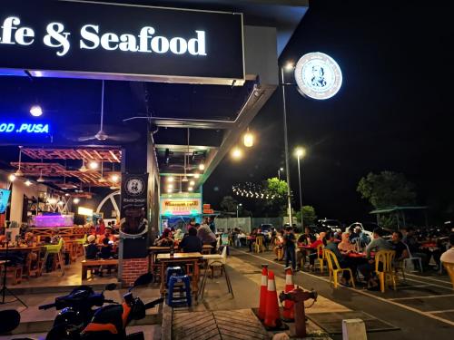 a crowd of people sitting at tables in front of a restaurant at Bell Suite @ Sepang By MHS in Sepang