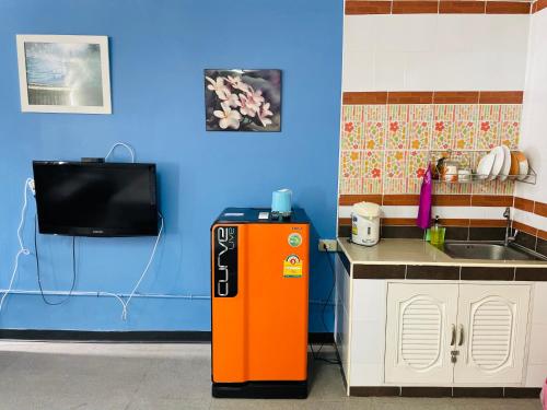 an orange refrigerator in a kitchen with a sink at Muangthong C3near Impact in Nonthaburi