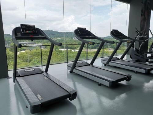 a gym with two treadmills in front of a window at Bell Suite @ Sepang By MHS in Sepang