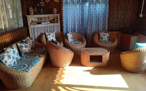 a room with several wicker chairs and a table at Megitar Homestay by StayApart in Bijanbāri Bāzār