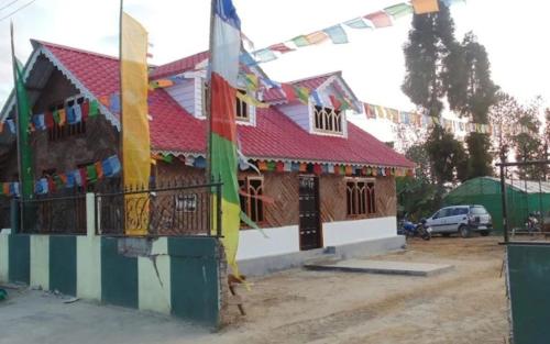 a house with prayer flags in front of it at Megitar Homestay by StayApart in Bijanbāri Bāzār