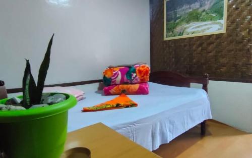 a table with a white table cloth and a potted plant at Megitar Homestay by StayApart in Bijanbāri Bāzār